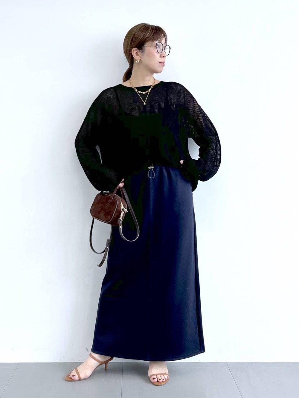 ブラウン系のサンダル、ブラック系のニット/セーター、ブルー系のスカートを着用したレディースの夏コーディネートの4枚目の写真