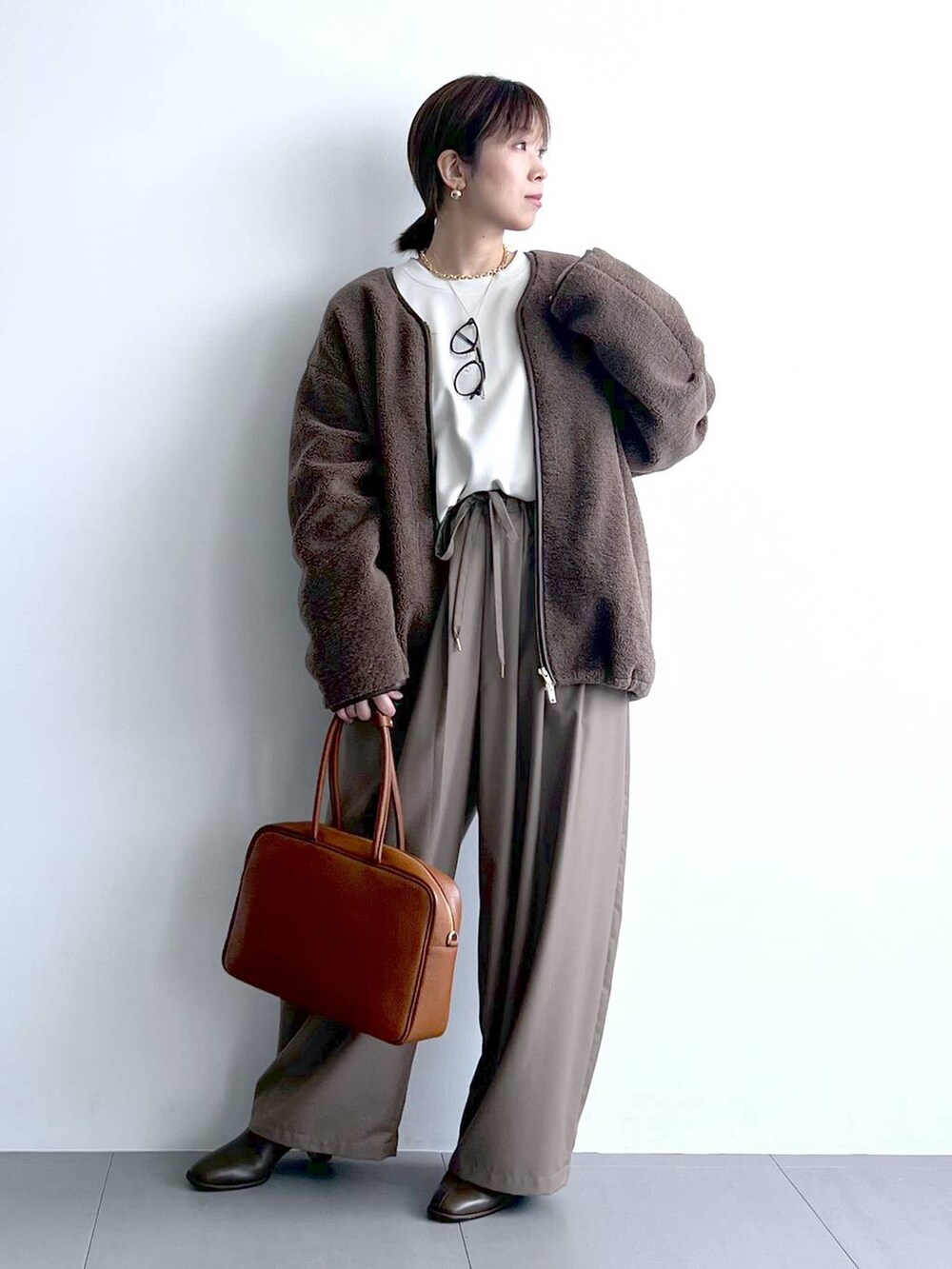 ベージュ系のその他パンツ、イエロー系のハンドバッグ、ブラウン系のブーツを着用したレディースの秋コーディネートの6枚目の写真