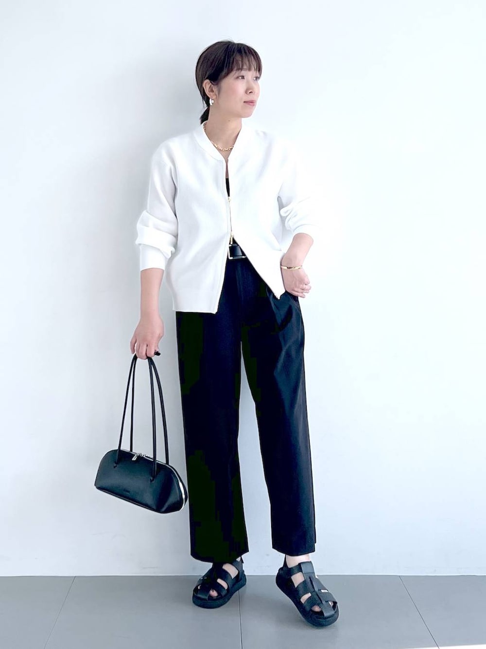 ブラック系のその他パンツ、ブラック系のハンドバッグ、ホワイト系のカーディガン/ボレロを着用したレディースの春コーディネートの8枚目の写真