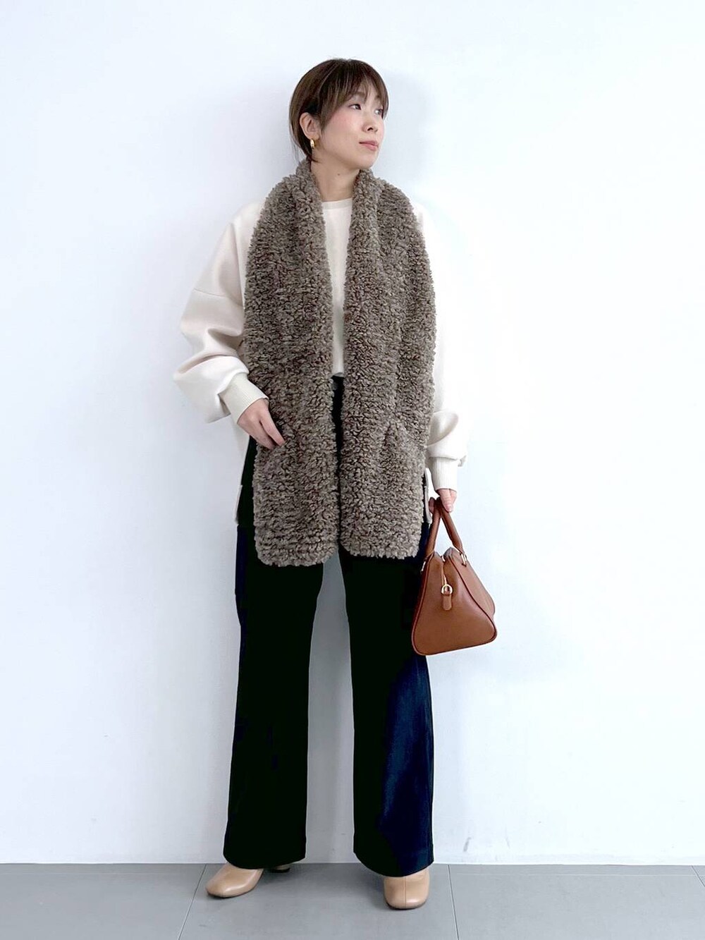 ブルー系のその他パンツ、イエロー系のボストンバッグ、ベージュ系のブーツを着用したレディースの秋コーディネートの4枚目の写真