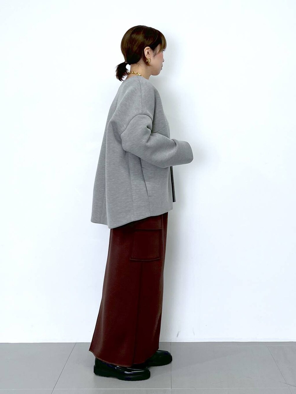 ブラウン系のスカート、ホワイト系のショルダーバッグ、ホワイト系のTシャツ/カットソーを着用したレディースの秋コーディネートの7枚目の写真