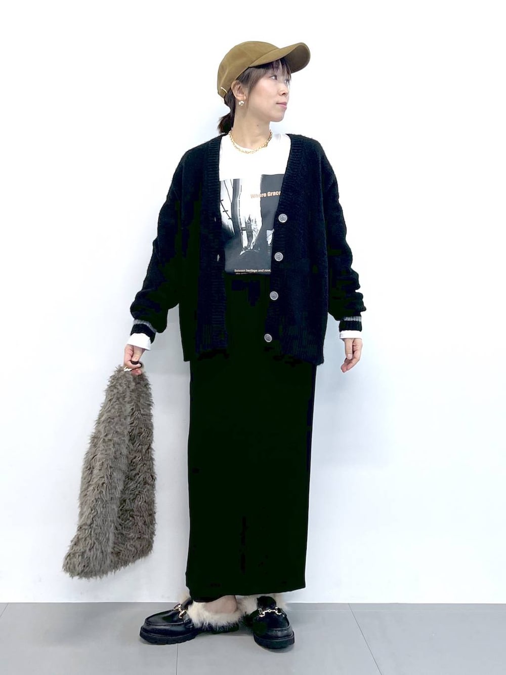 ブラック系のスカート、ブラック系のカーディガン/ボレロ、ブラウン系のハンドバッグを着用したレディースの秋コーディネートの5枚目の写真