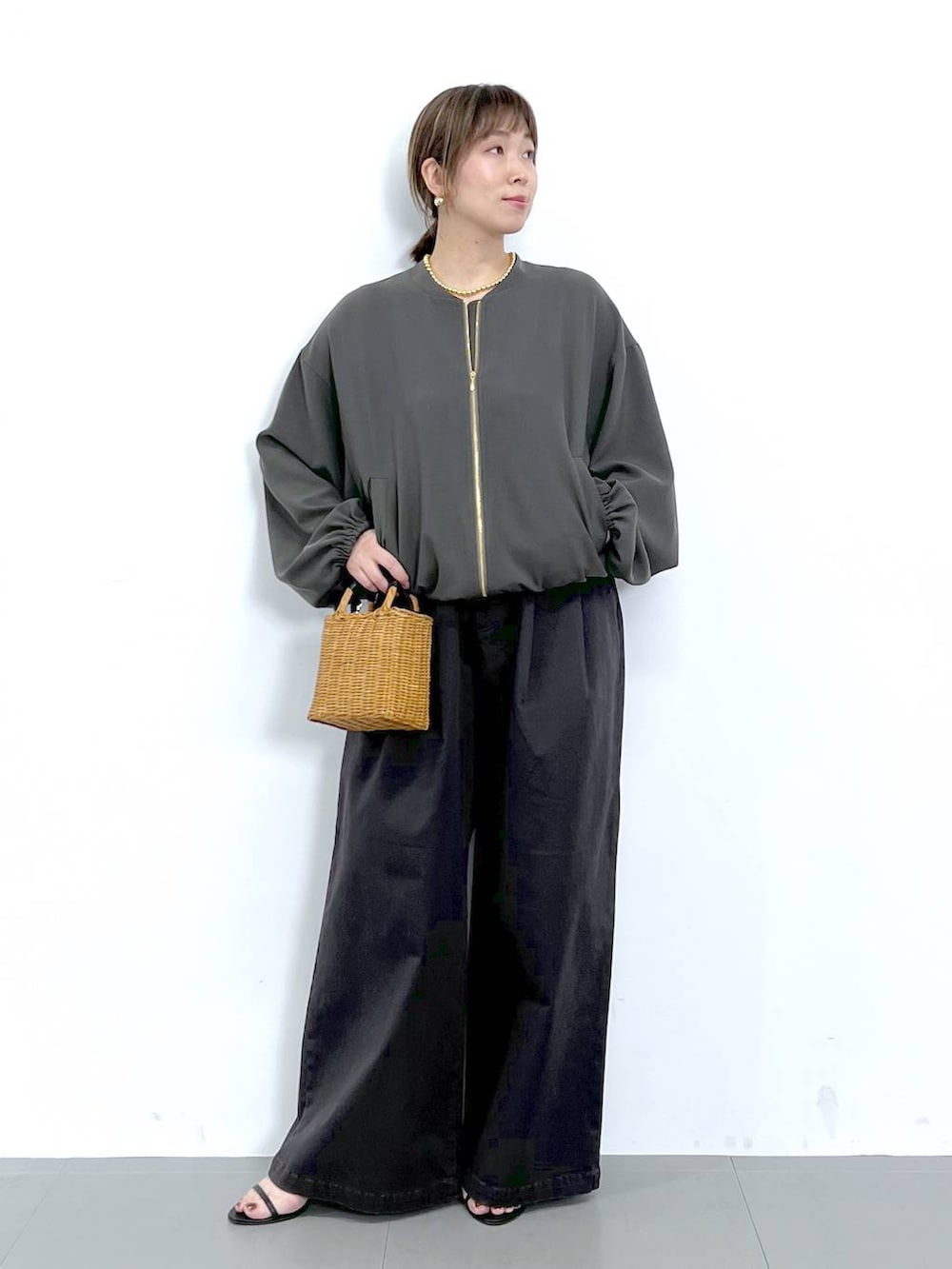 グレー系のブルゾン、ブラック系のショルダーバッグ、ブラック系のサンダルを着用したレディースの秋コーディネートの6枚目の写真