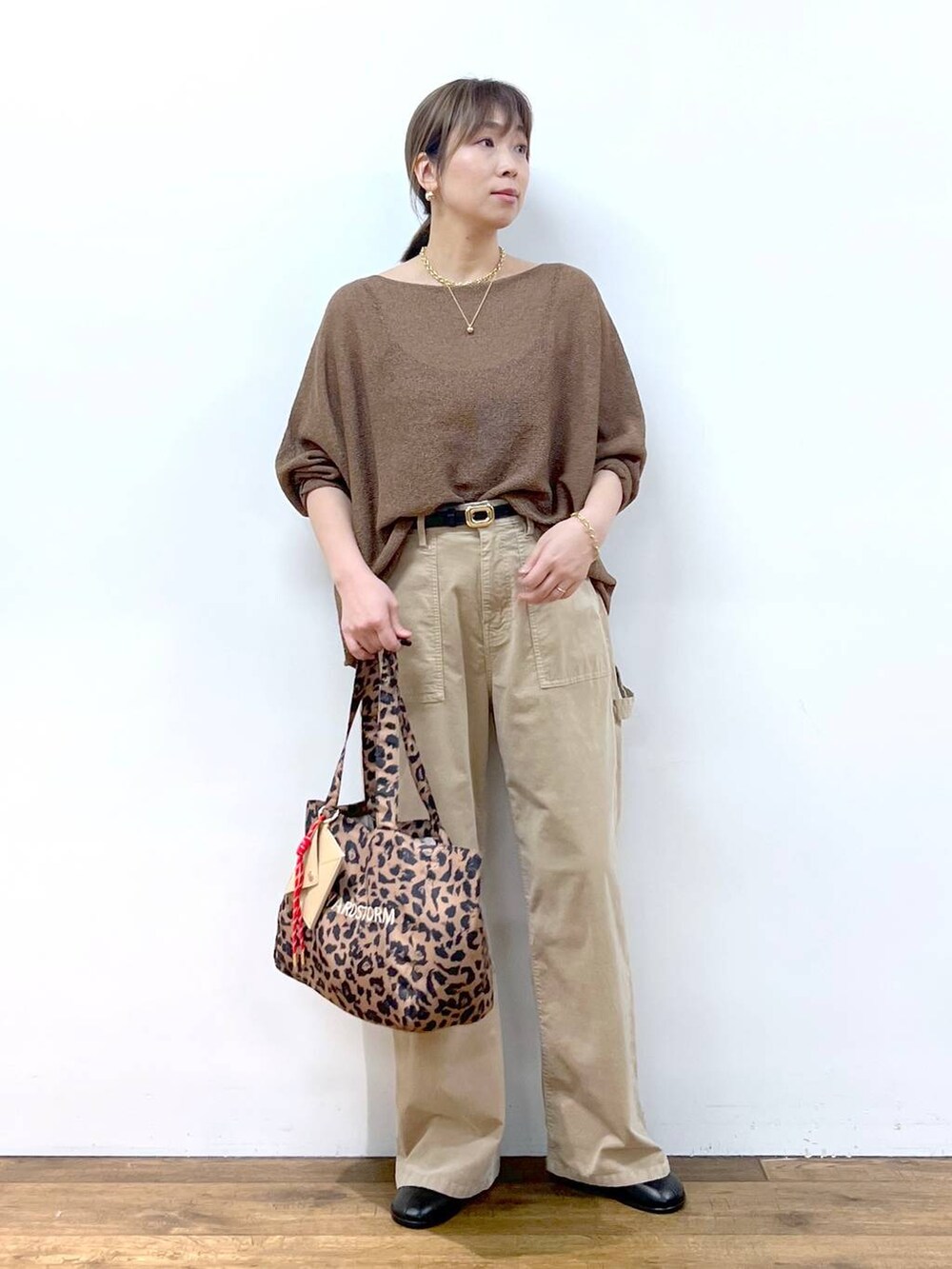 ブラウン系のニット/セーター、ブラウン系のトートバッグ、その他のピアス（両耳用）を着用したレディースの夏コーディネートの5枚目の写真