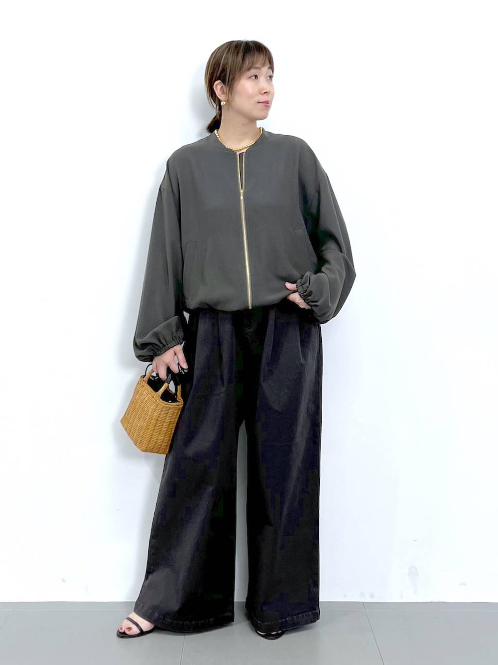 グレー系のブルゾン、ブラック系のショルダーバッグ、ブラック系のサンダルを着用したレディースの秋コーディネートの7枚目の写真