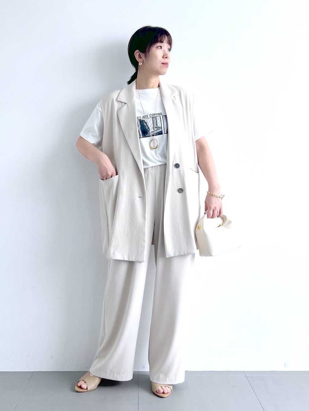 ホワイト系のベスト、ホワイト系のその他パンツ、ホワイト系のTシャツ/カットソーを着用したレディースの春コーディネートの3枚目の写真