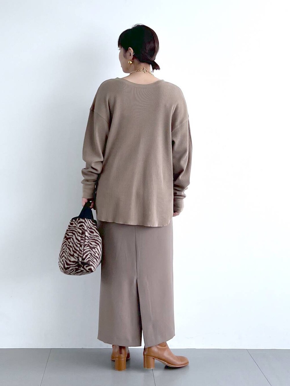 ブラウン系のスカート、イエロー系のブーツ、その他のトートバッグを着用したレディースの秋コーディネートの10枚目の写真