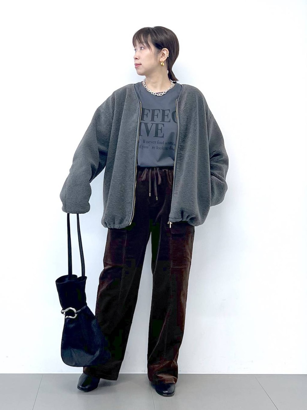 ブラック系のブーツ、グレー系のブルゾン、シルバー系のネックレスを着用したレディースの秋コーディネートの5枚目の写真