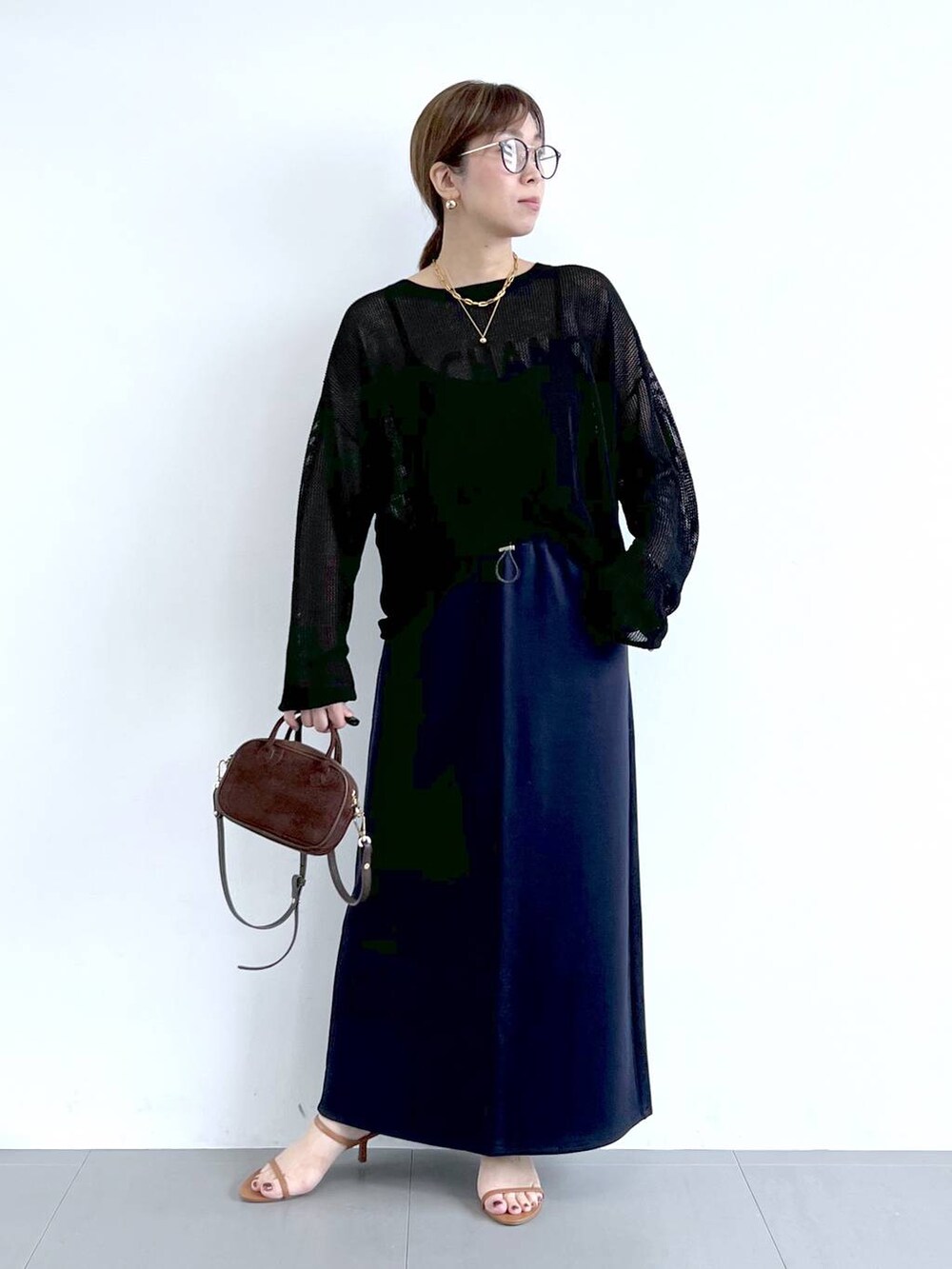 ブラウン系のサンダル、ブラック系のニット/セーター、ブルー系のスカートを着用したレディースの夏コーディネートの3枚目の写真