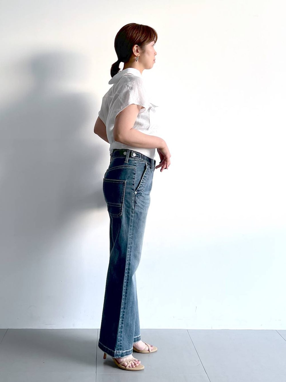ベージュ系のサンダル、ホワイト系のシャツ/ブラウス、ブルー系のデニムパンツを着用したレディースの夏コーディネートの7枚目の写真