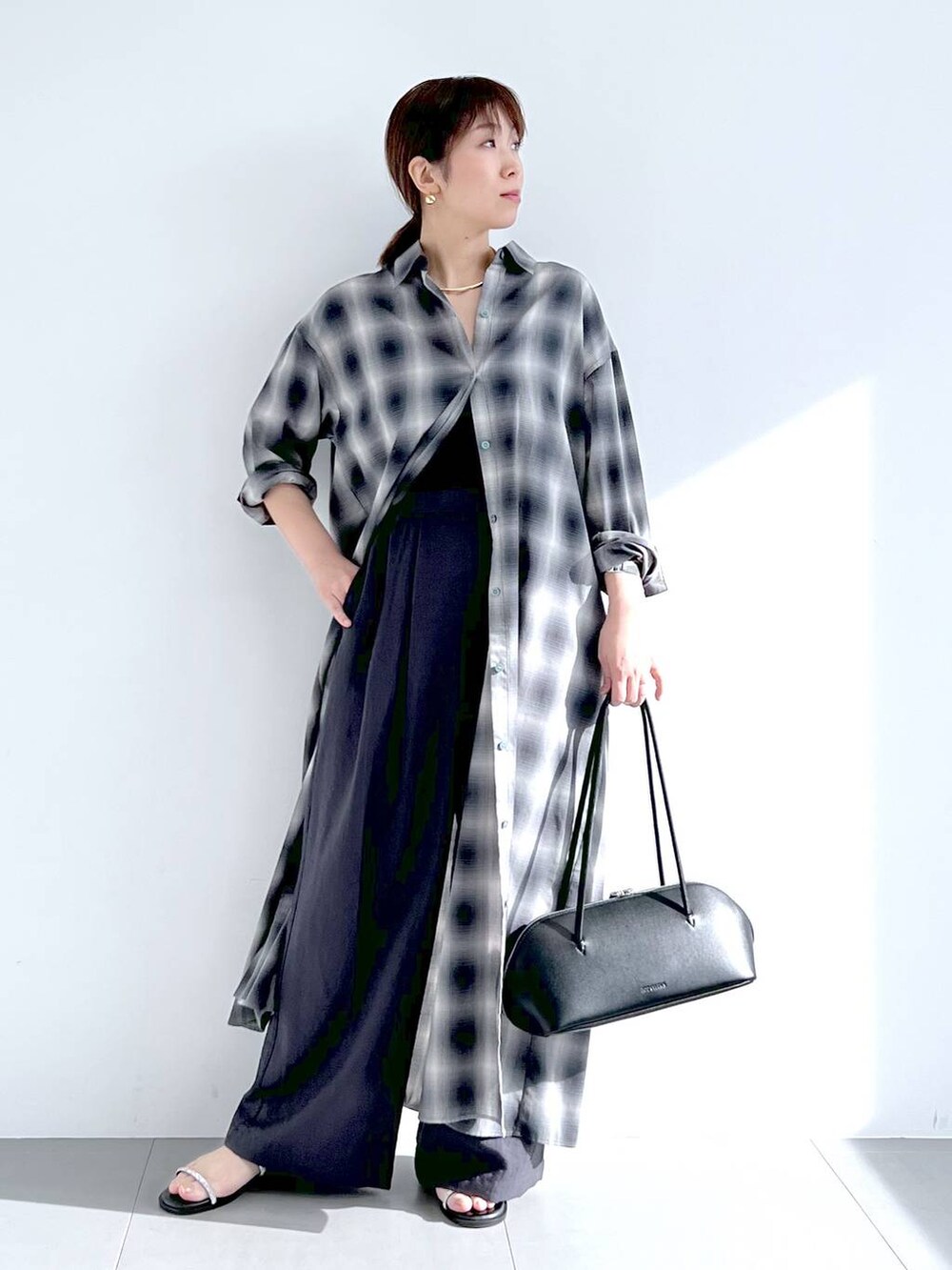 ブラック系のトートバッグ、グレー系のシャツワンピース、グレー系のその他パンツを着用したレディースの春コーディネートの2枚目の写真