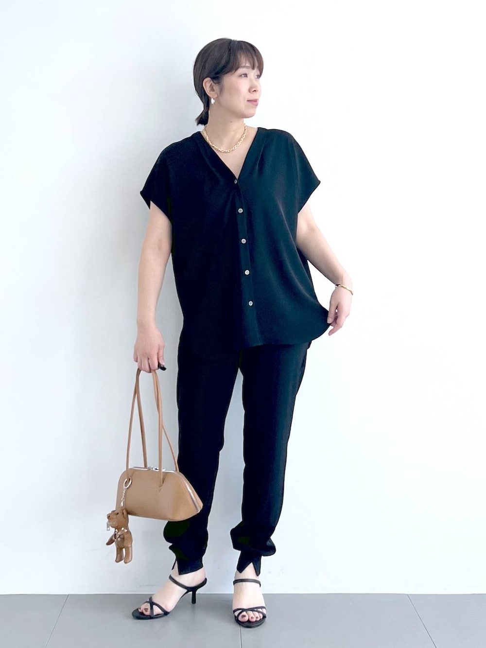 ブラウン系のハンドバッグ、ブラック系のシャツ/ブラウス、ブラック系のサンダルを着用したレディースの春コーディネートの4枚目の写真