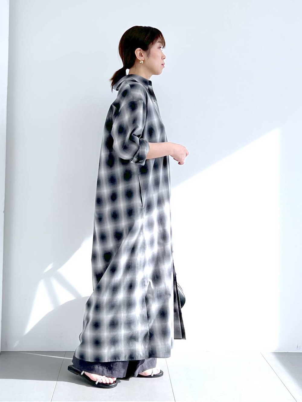 ブラック系のトートバッグ、グレー系のシャツワンピース、グレー系のその他パンツを着用したレディースの春コーディネートの8枚目の写真