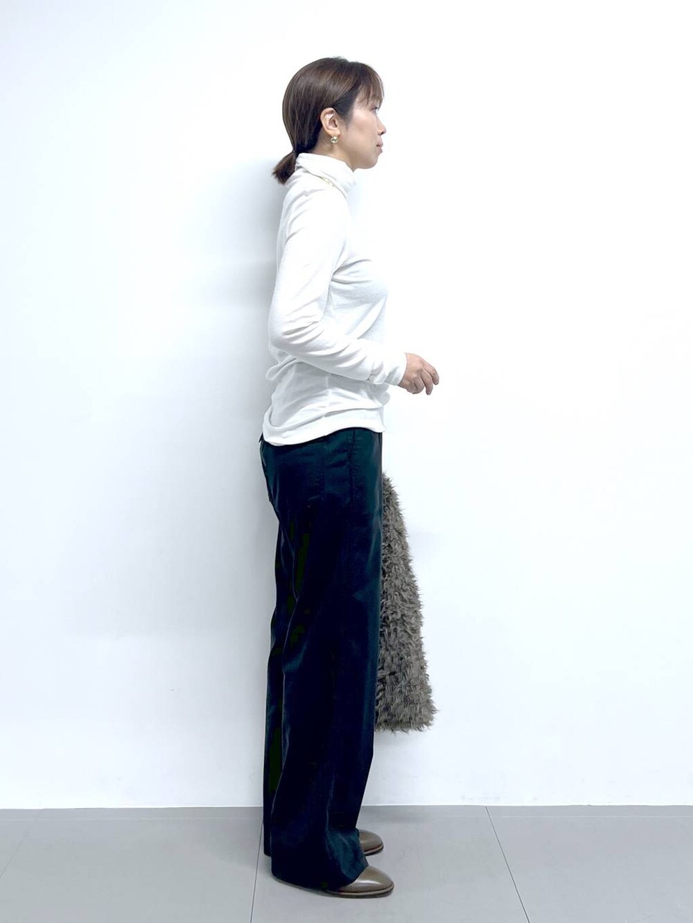 ブラック系のチノパンツ、ホワイト系のTシャツ/カットソー、ブラウン系のハンドバッグを着用したレディースの秋コーディネートの5枚目の写真