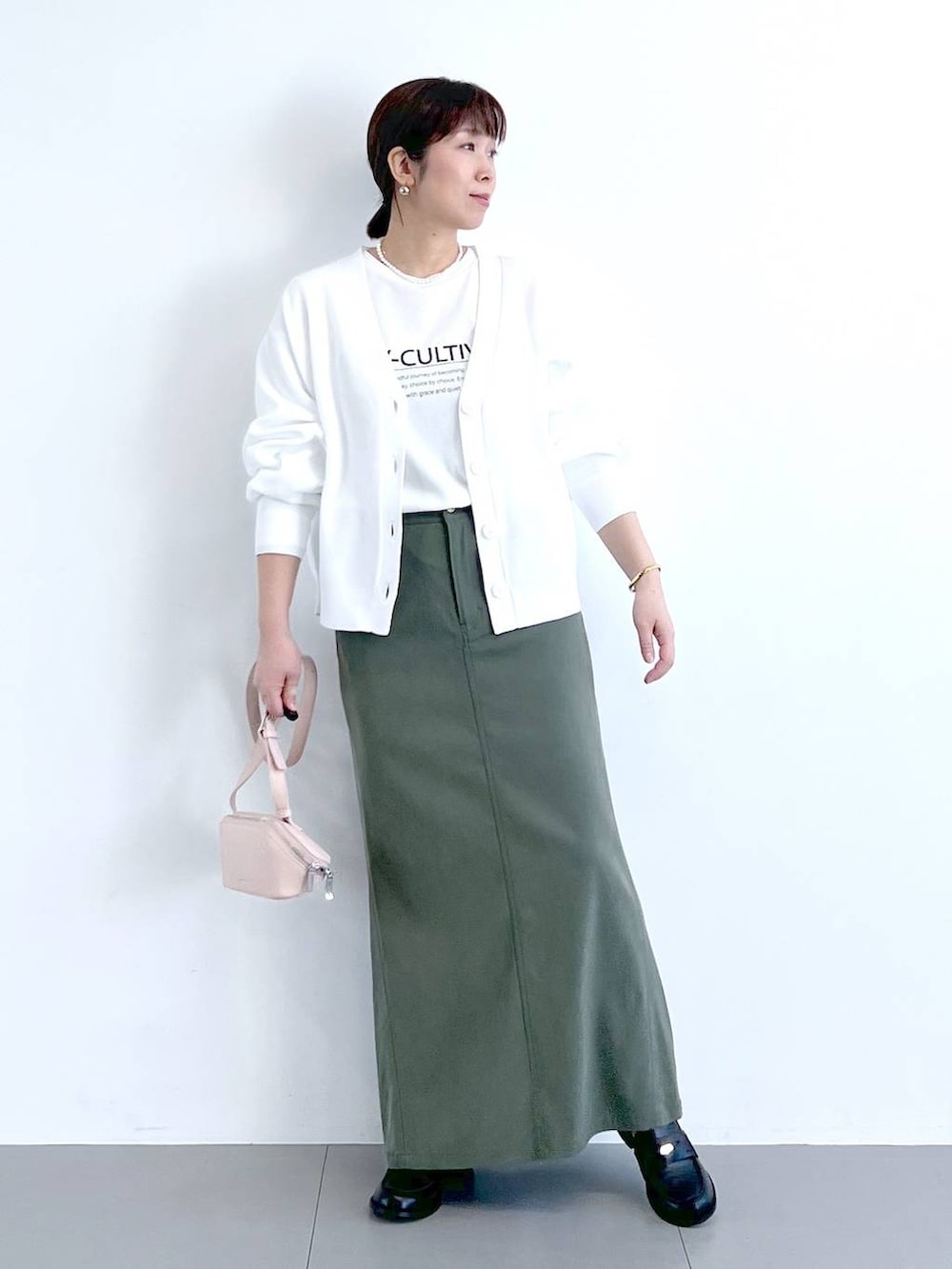 ホワイト系のTシャツ/カットソー、グリーン系のスカート、ピンク系のショルダーバッグを着用したレディースの冬コーディネートの5枚目の写真