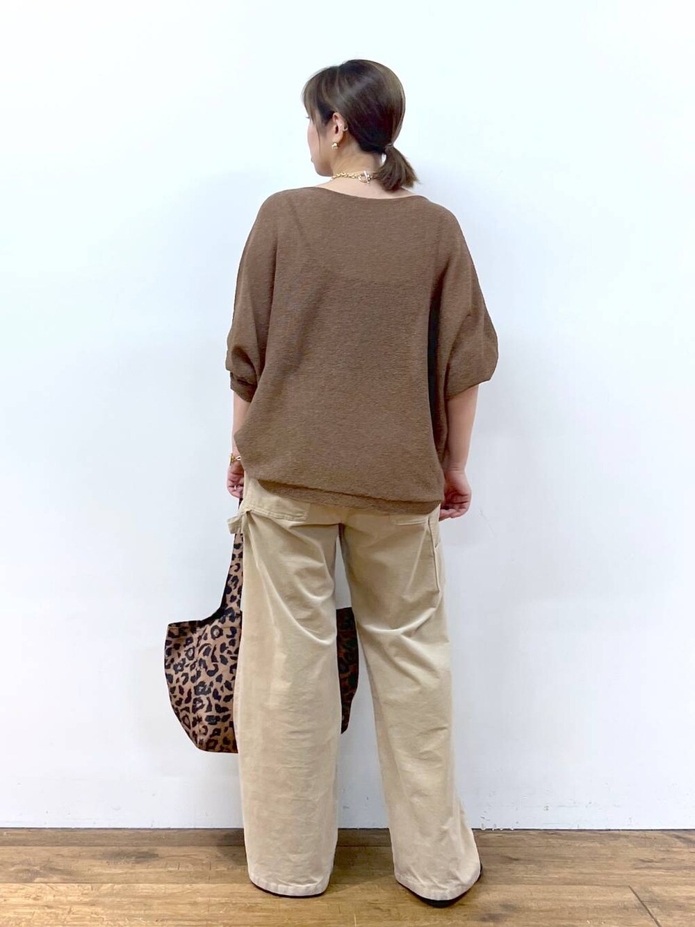 ブラウン系のニット/セーター、ブラウン系のトートバッグ、その他のピアス（両耳用）を着用したレディースの夏コーディネートの9枚目の写真