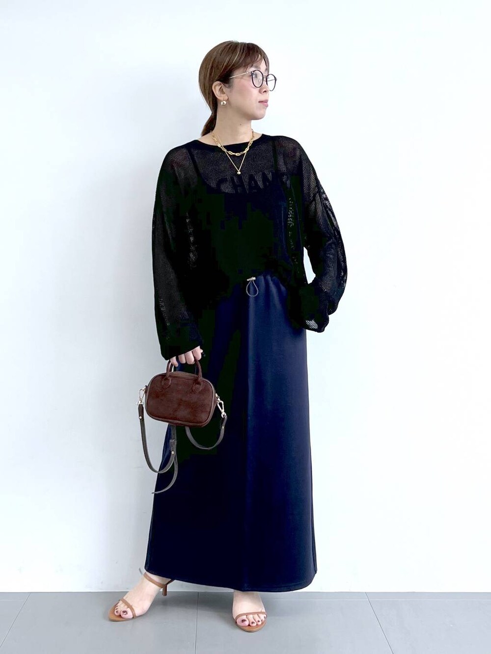 ブラウン系のサンダル、ブラック系のニット/セーター、ブルー系のスカートを着用したレディースの夏コーディネートの2枚目の写真