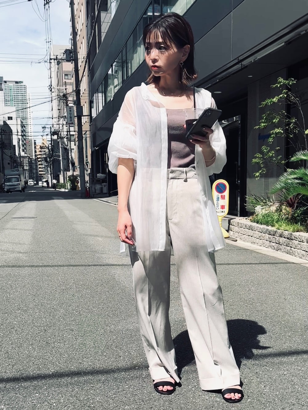 ブラウン系のタンクトップ、ベージュ系のパンツ、ホワイト系のシャツ/ブラウスを着用したレディースの夏コーディネートの2枚目の写真