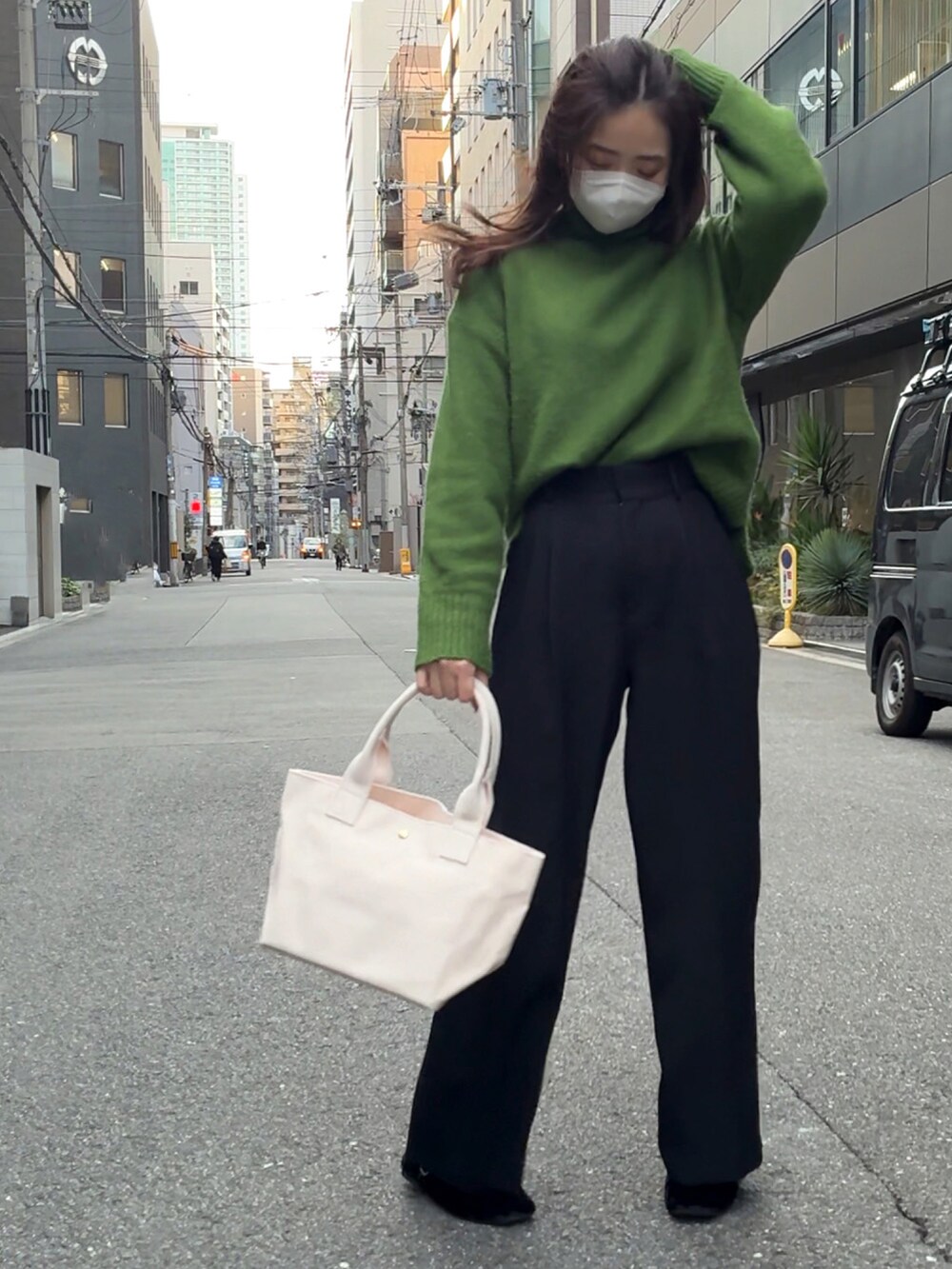 ホワイト系のトートバッグ、グリーン系のニット/セーター、ブラック系のスラックスを着用したレディースの冬コーディネートの5枚目の写真
