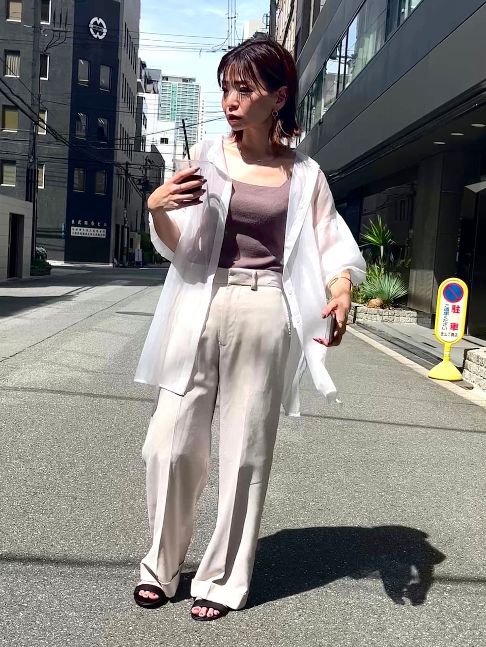 ブラウン系のタンクトップ、ベージュ系のパンツ、ホワイト系のシャツ/ブラウスを着用したレディースの夏コーディネートの3枚目の写真