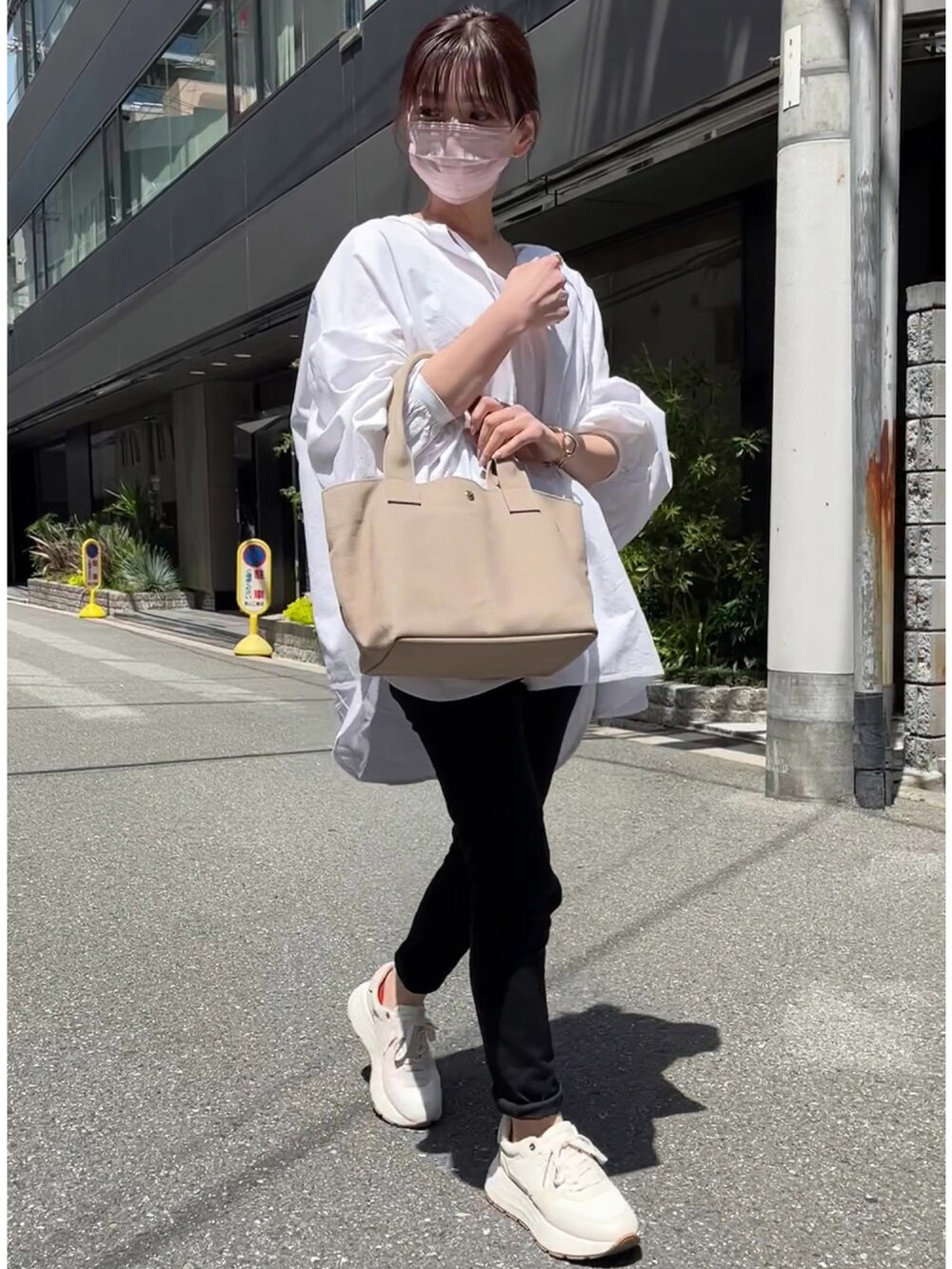 グレー系のトートバッグ、ホワイト系のシャツ/ブラウス、ホワイト系のスニーカーを着用したレディースの春コーディネートの2枚目の写真