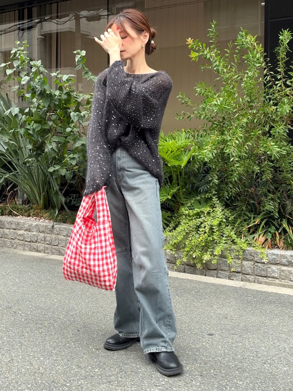 ブラック系のニット/セーター、ブルー系のデニムパンツ、レッド系のエコバッグ/サブバッグを着用したレディースの秋コーディネートの3枚目の写真