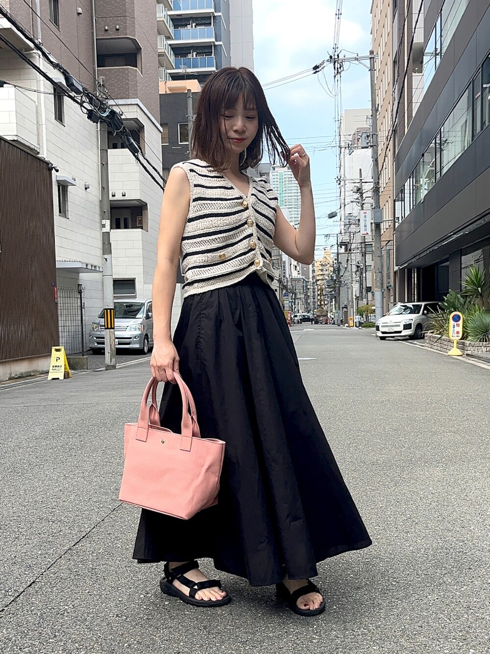 ホワイト系のトップス、ピンク系のトートバッグ、ブラック系のスカートを着用したレディースの秋コーディネートの3枚目の写真