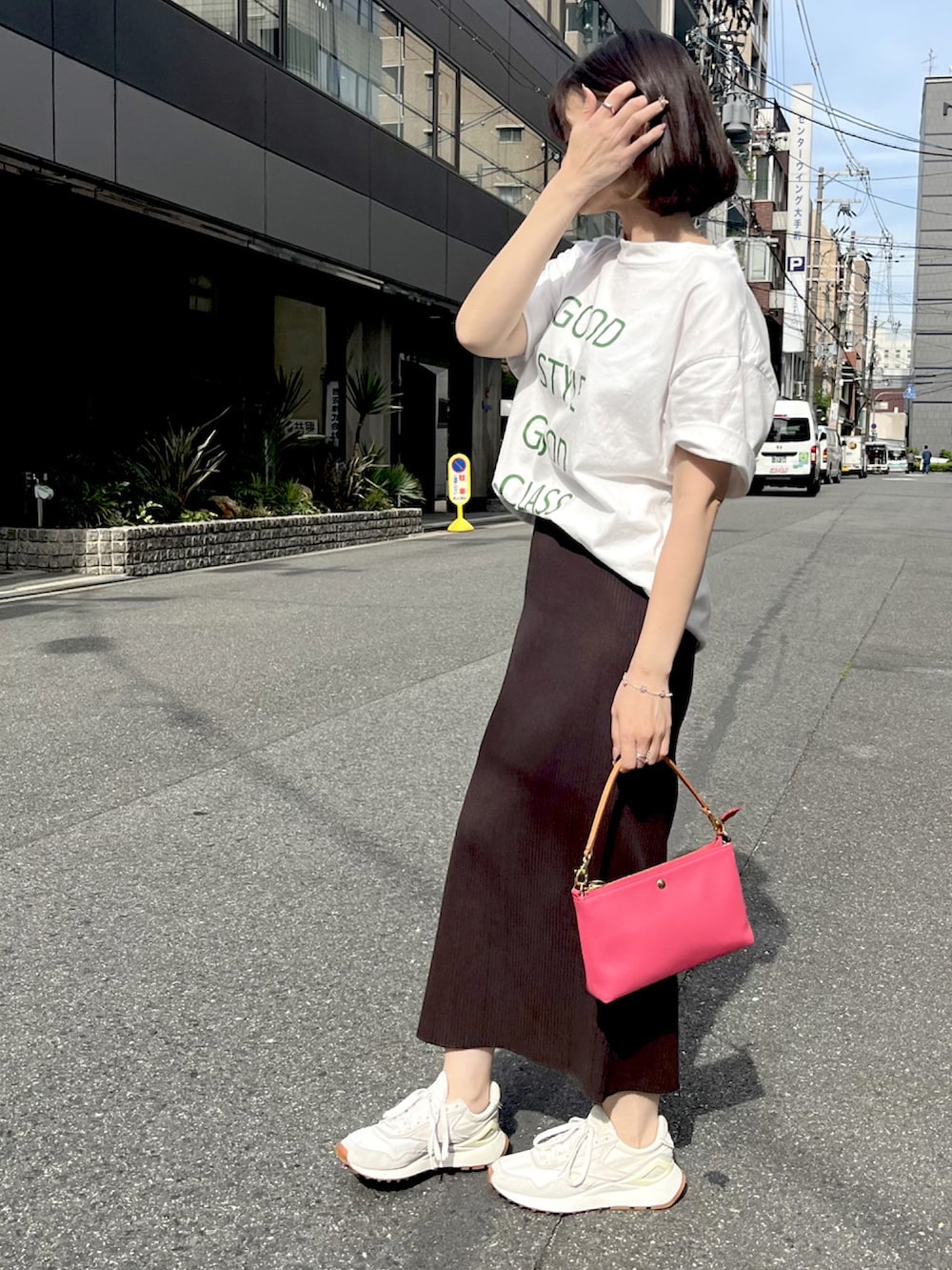 ホワイト系のTシャツ/カットソー、ブラウン系のスカート、ピンク系のハンドバッグを着用したレディースの春コーディネートの2枚目の写真