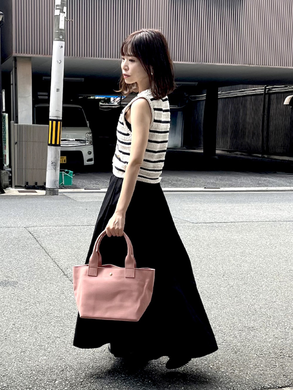 ホワイト系のトップス、ピンク系のトートバッグ、ブラック系のスカートを着用したレディースの秋コーディネートの4枚目の写真