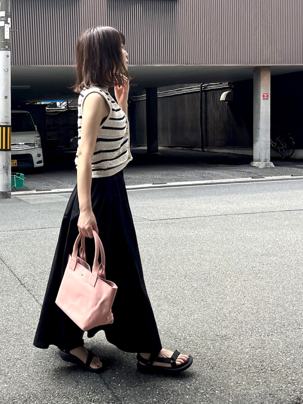 ホワイト系のトップス、ピンク系のトートバッグ、ブラック系のスカートを着用したレディースの秋コーディネートの2枚目の写真