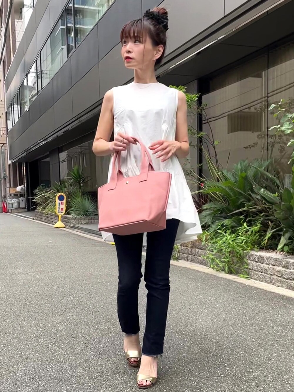 ピンク系のトートバッグ、ホワイト系のシャツ/ブラウス、ブルー系のデニムパンツを着用したレディースの夏コーディネートの2枚目の写真