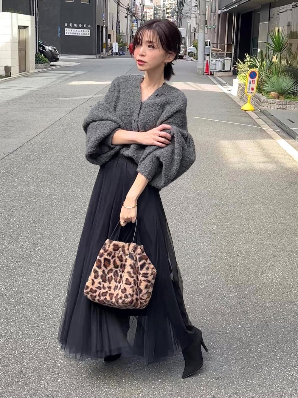 グレー系のカーディガン/ボレロ、ブラック系のスカート、ブラウン系のバッグを着用したレディースの秋コーディネートの3枚目の写真