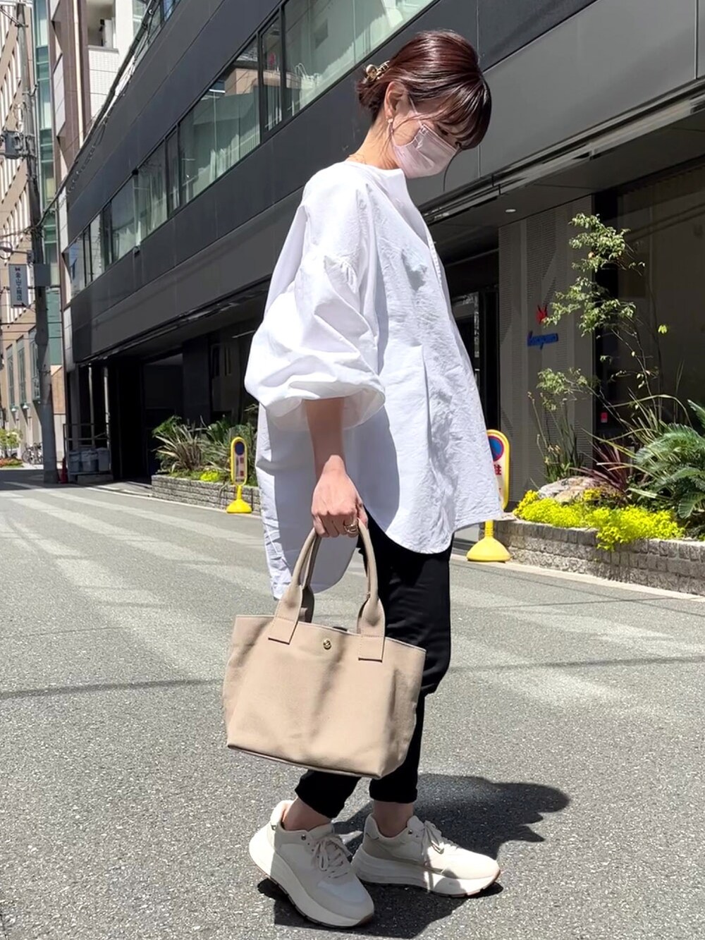 グレー系のトートバッグ、ホワイト系のシャツ/ブラウス、ホワイト系のスニーカーを着用したレディースの春コーディネートの3枚目の写真