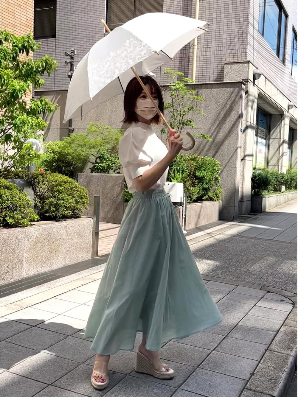 ホワイト系のシャツ/ブラウス、グリーン系のスカート、ベージュ系のサンダルを着用したレディースの夏コーディネートの3枚目の写真