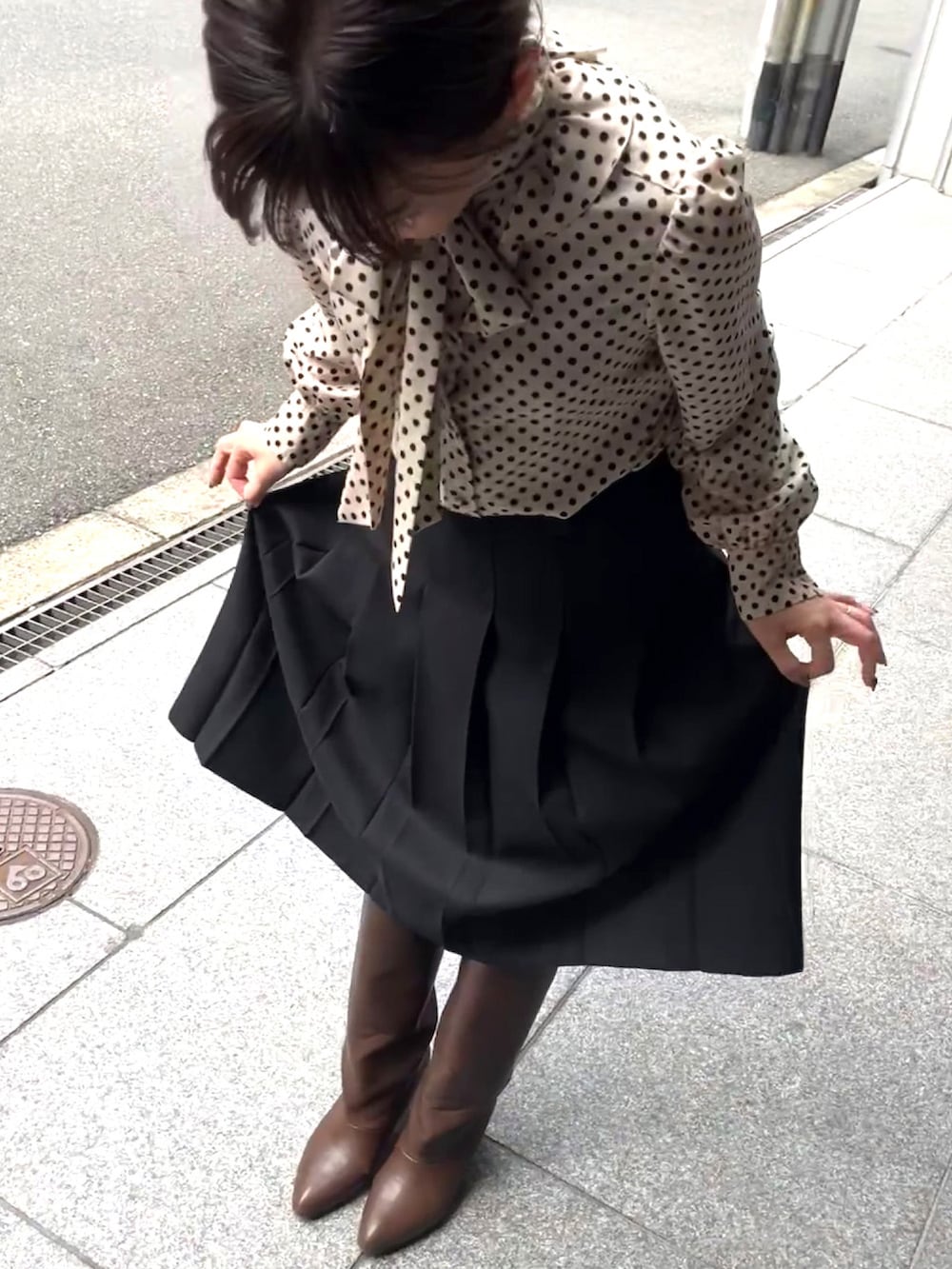 ベージュ系のシャツ/ブラウス、ブラック系のスカート、ブラウン系のハンドバッグを着用したレディースの秋コーディネートの4枚目の写真