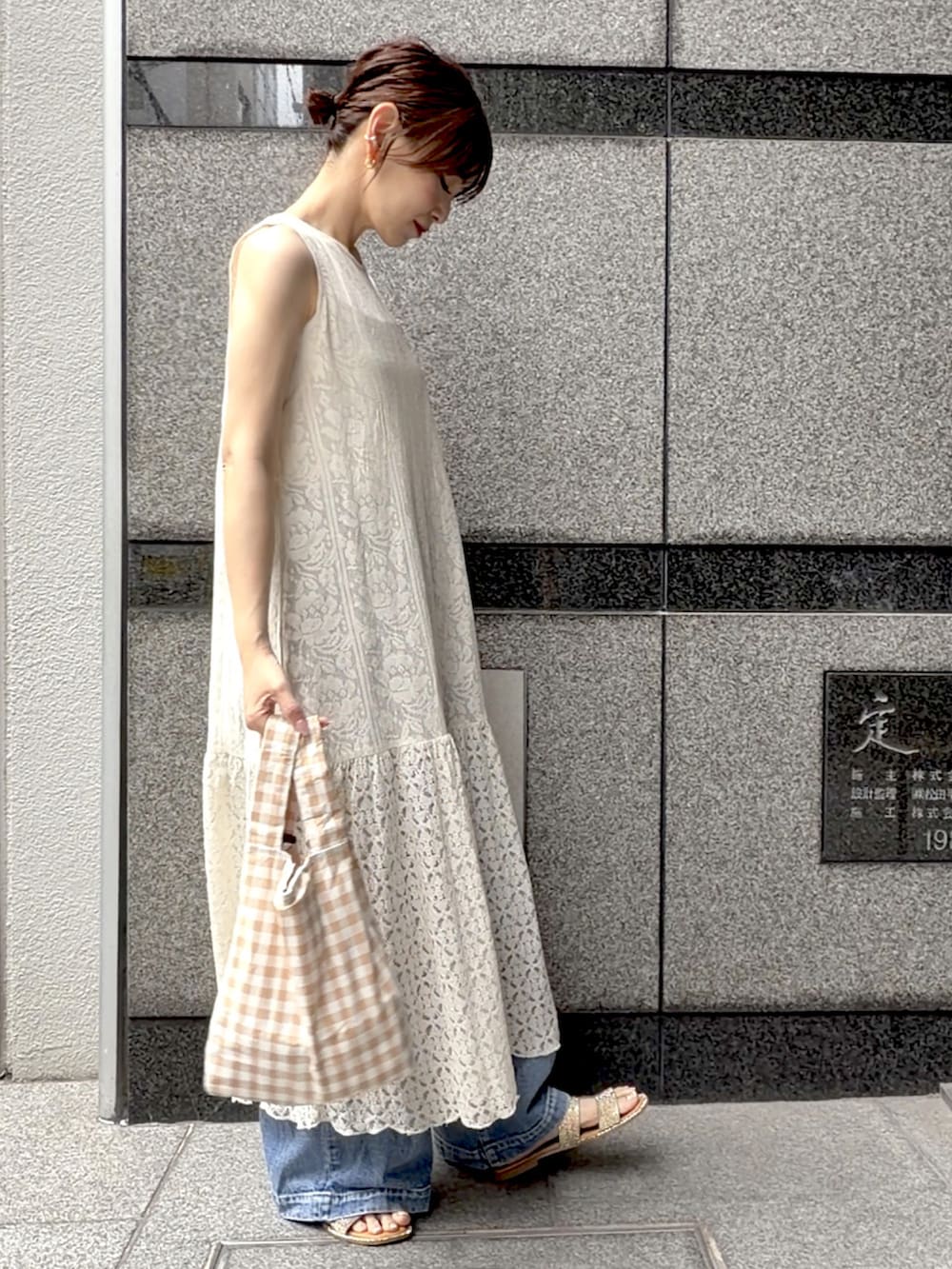 ベージュ系のワンピース、ベージュ系のエコバッグ/サブバッグ、ブルー系のデニムパンツを着用したレディースの夏コーディネートの5枚目の写真