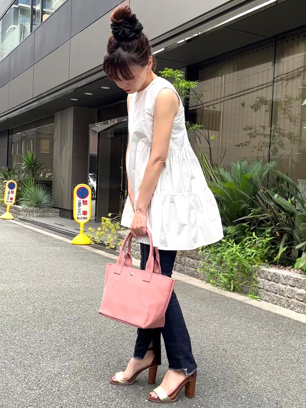 ピンク系のトートバッグ、ホワイト系のシャツ/ブラウス、ブルー系のデニムパンツを着用したレディースの夏コーディネートの4枚目の写真