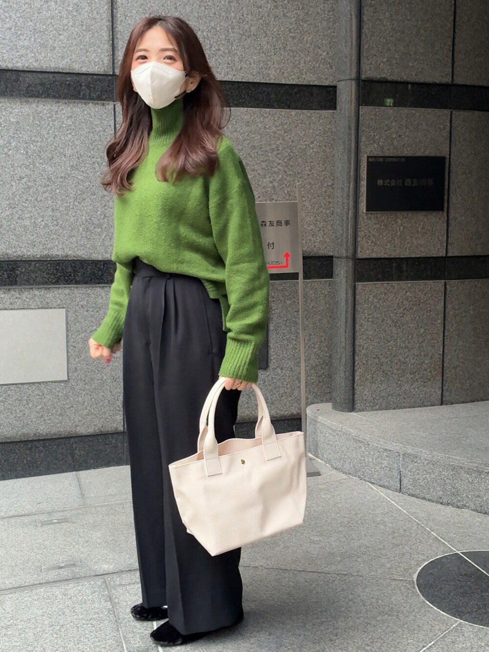 ホワイト系のトートバッグ、グリーン系のニット/セーター、ブラック系のスラックスを着用したレディースの冬コーディネートの4枚目の写真