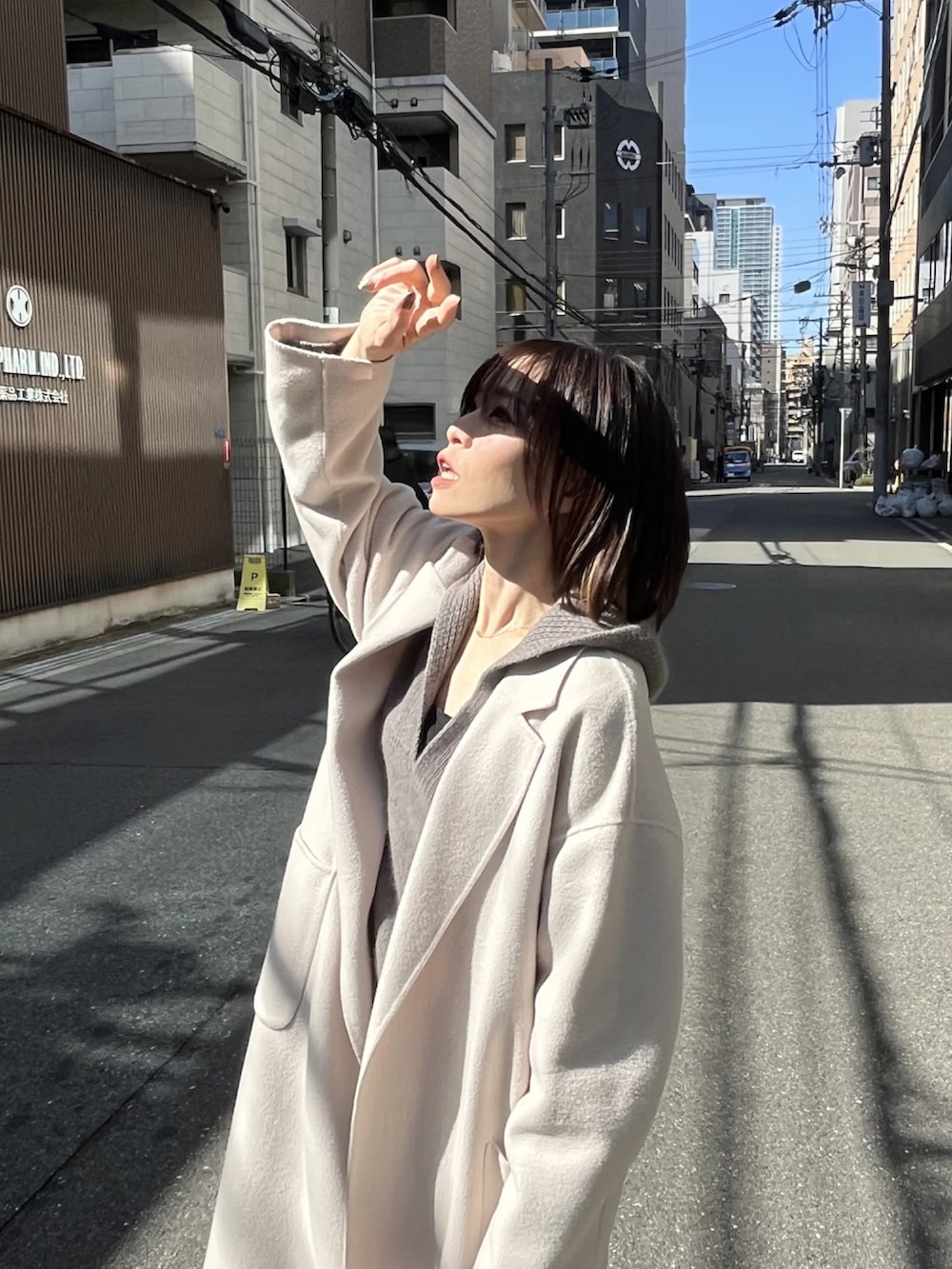 ピンク系のトートバッグ、ホワイト系のチェスターコート、グレー系のワンピースを着用したレディースの冬コーディネートの5枚目の写真