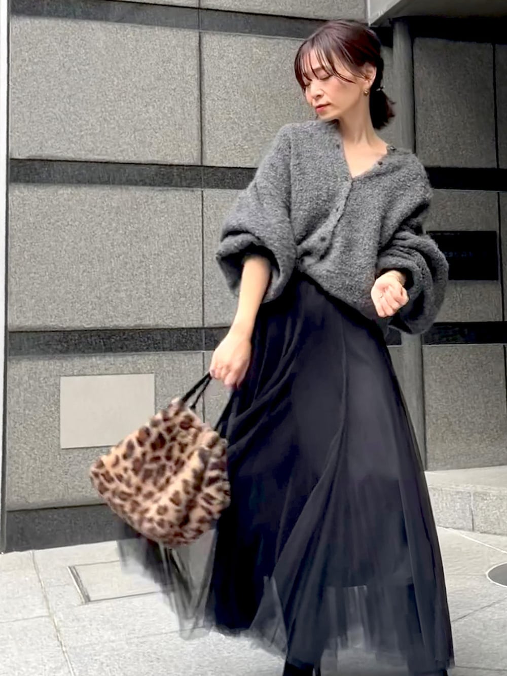 グレー系のカーディガン/ボレロ、ブラック系のスカート、ブラウン系のバッグを着用したレディースの秋コーディネートの4枚目の写真