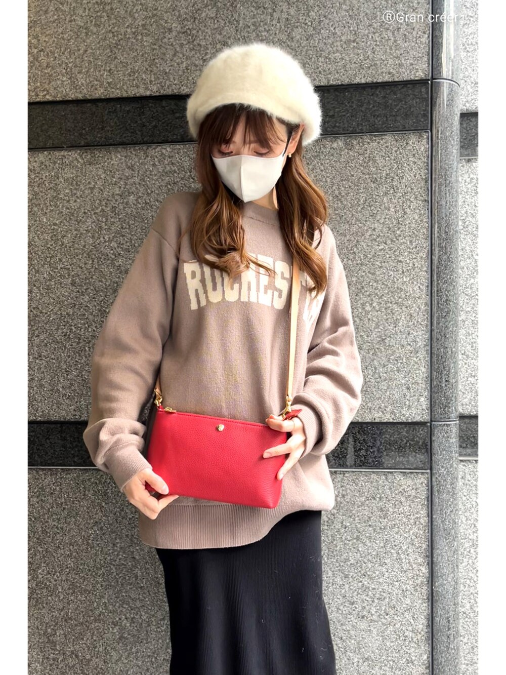 レッド系のショルダーバッグ、ブラック系のスカート、ホワイト系のブーツを着用したレディースの冬コーディネートの2枚目の写真