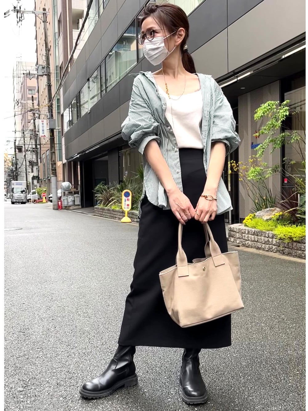グレー系のトートバッグ、グリーン系のシャツ/ブラウス、ブラック系のブーツを着用したレディースの春コーディネートの2枚目の写真