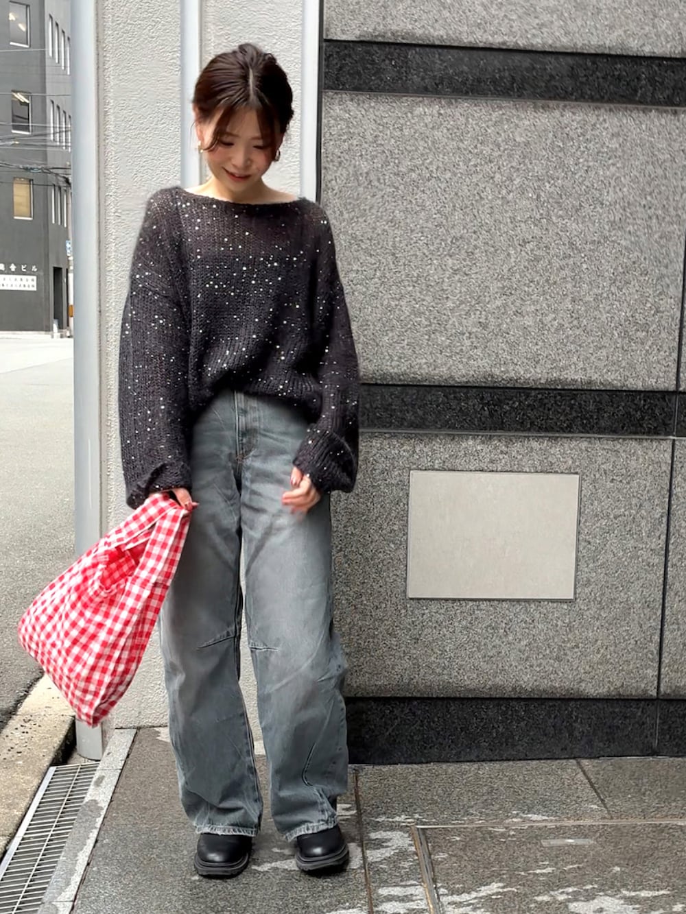 ブラック系のニット/セーター、ブルー系のデニムパンツ、レッド系のエコバッグ/サブバッグを着用したレディースの秋コーディネートの4枚目の写真