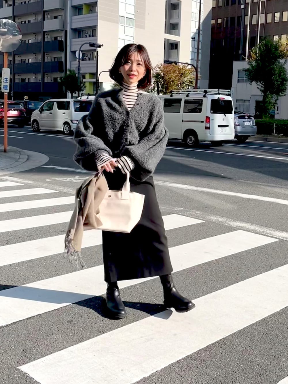 ホワイト系のトートバッグ、グレー系のカーディガン/ボレロ、ブラック系のスカートを着用したレディースの秋コーディネートの3枚目の写真