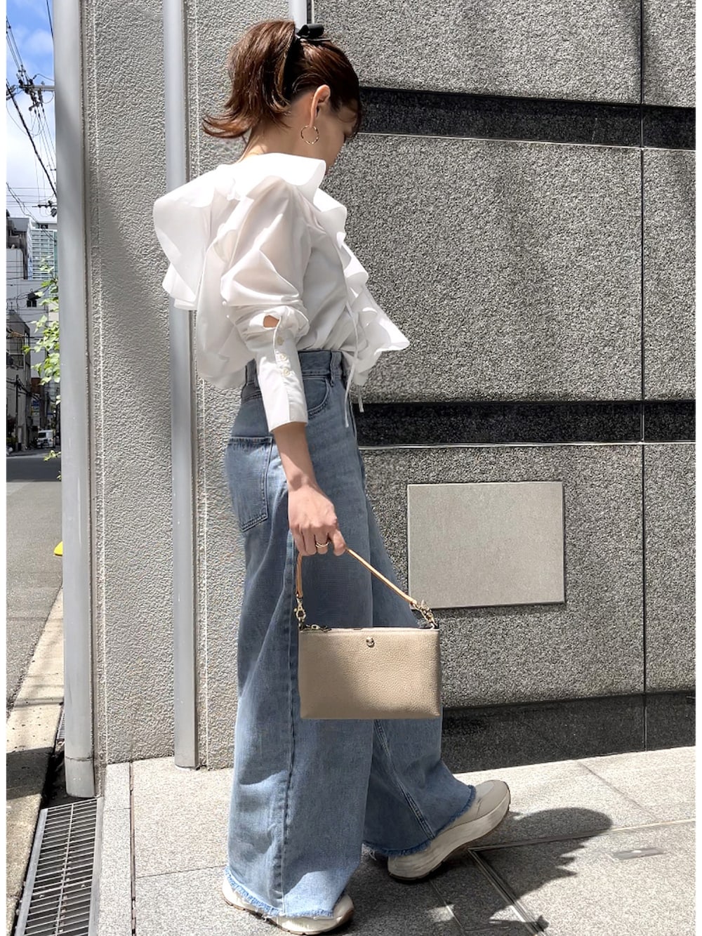 グレー系のショルダーバッグ、ホワイト系のシャツ/ブラウス、グレー系のデニムパンツを着用したレディースの春コーディネートの4枚目の写真
