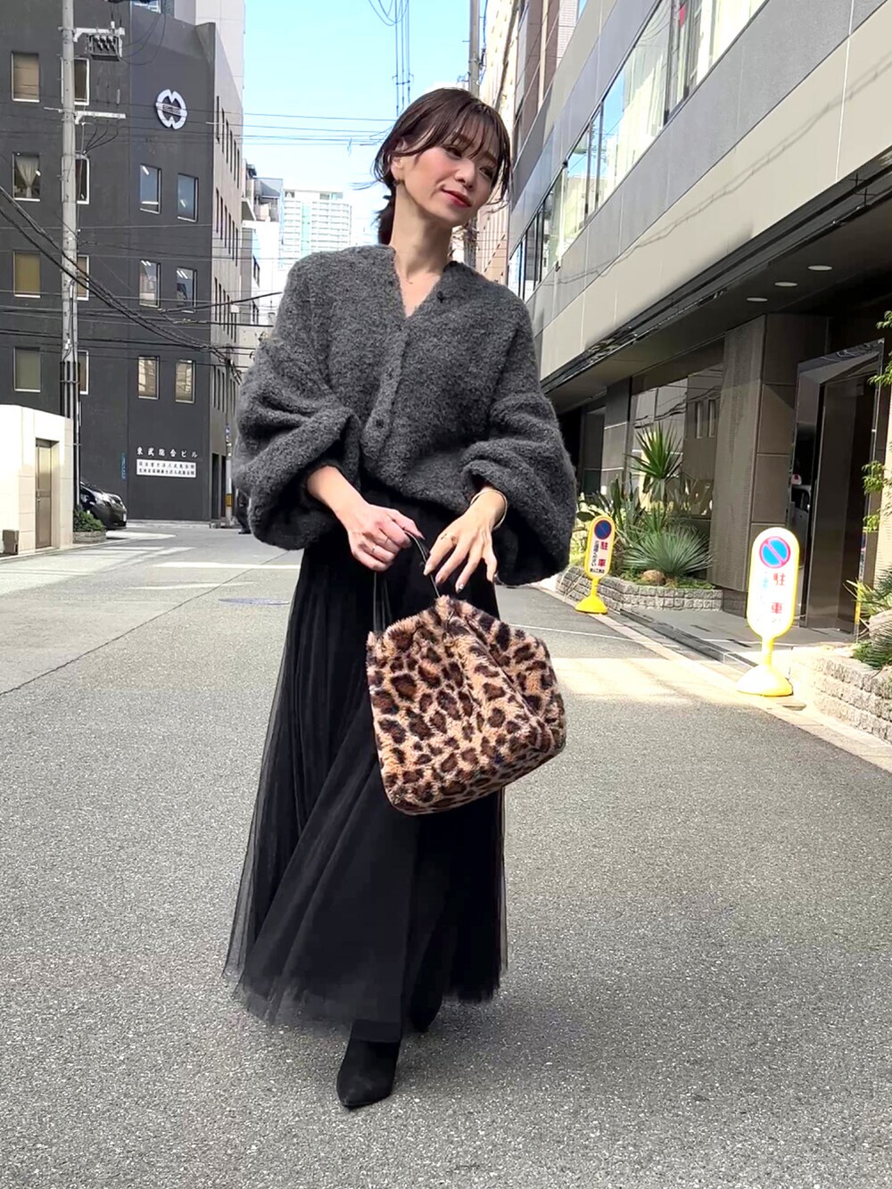 グレー系のカーディガン/ボレロ、ブラック系のスカート、ブラウン系のバッグを着用したレディースの秋コーディネートの2枚目の写真