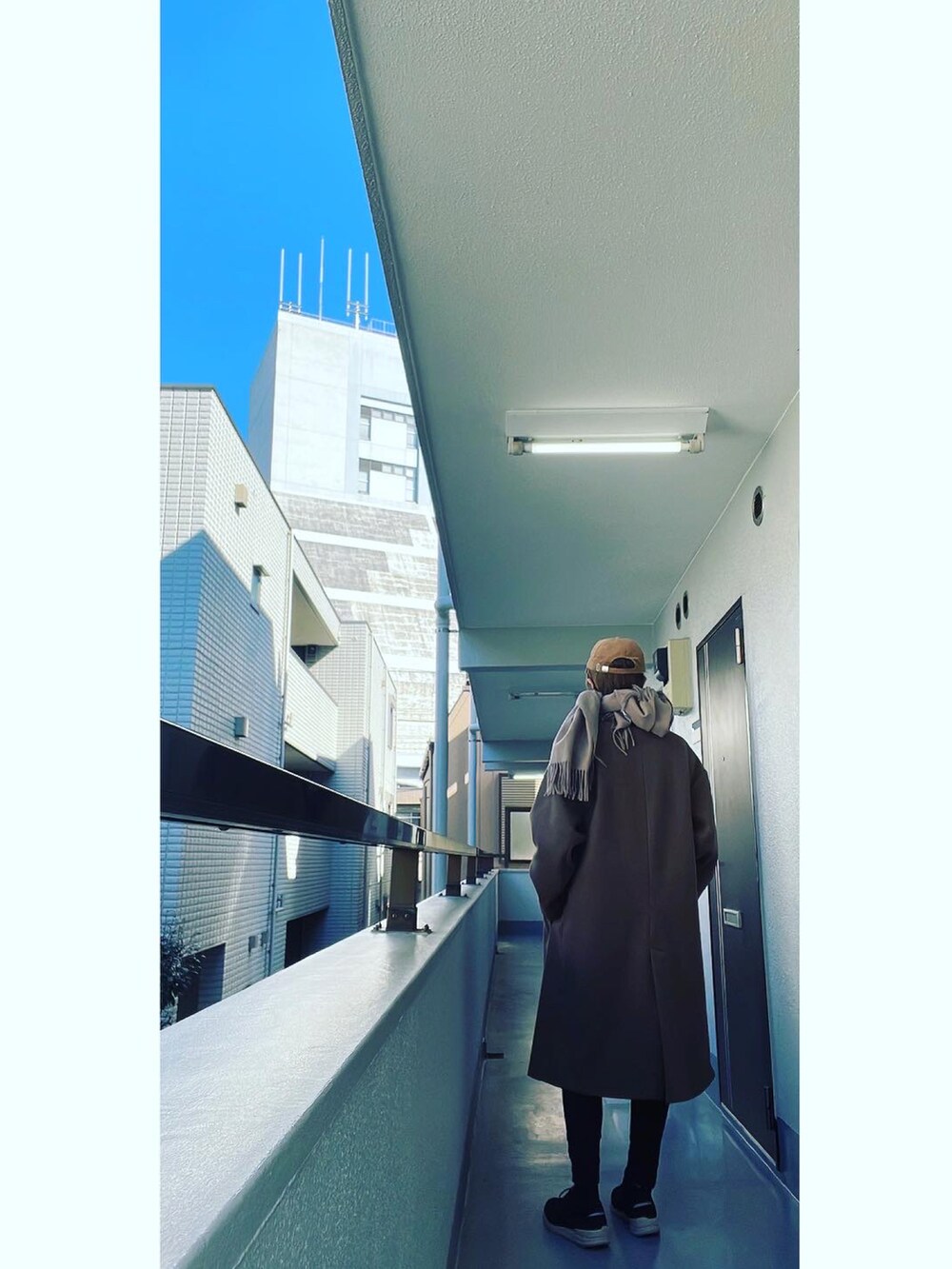 ブラウン系のチェスターコート、ブラック系のベスト、ホワイト系のTシャツ/カットソーを着用したメンズの冬コーディネートの3枚目の写真