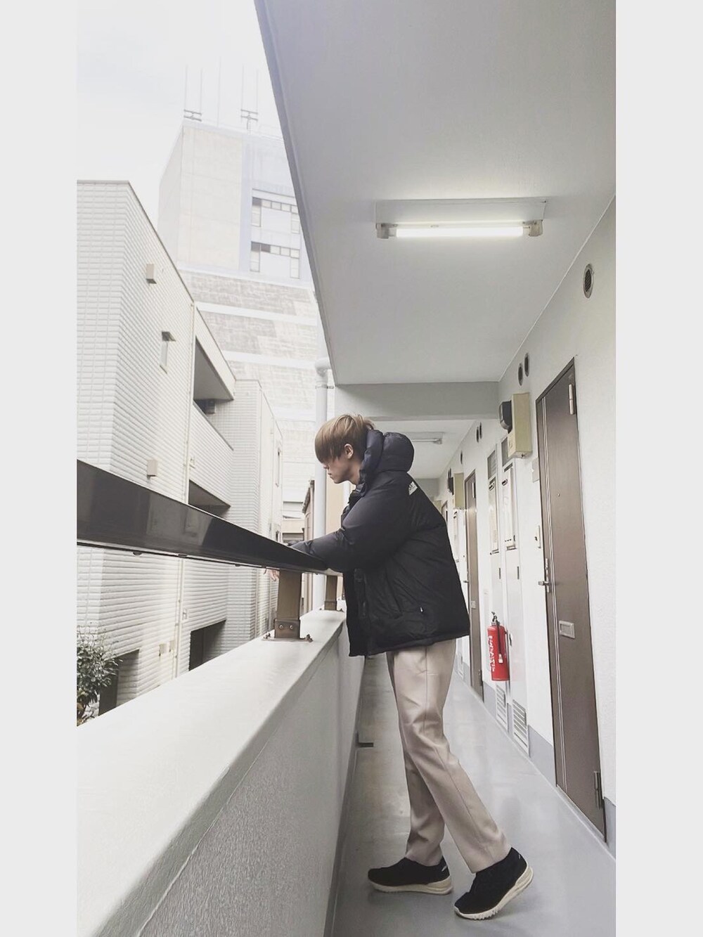 ブラック系のダウンジャケット/コート、ブラック系のTシャツ/カットソー、ベージュ系のスラックスを着用したメンズの冬コーディネートの2枚目の写真