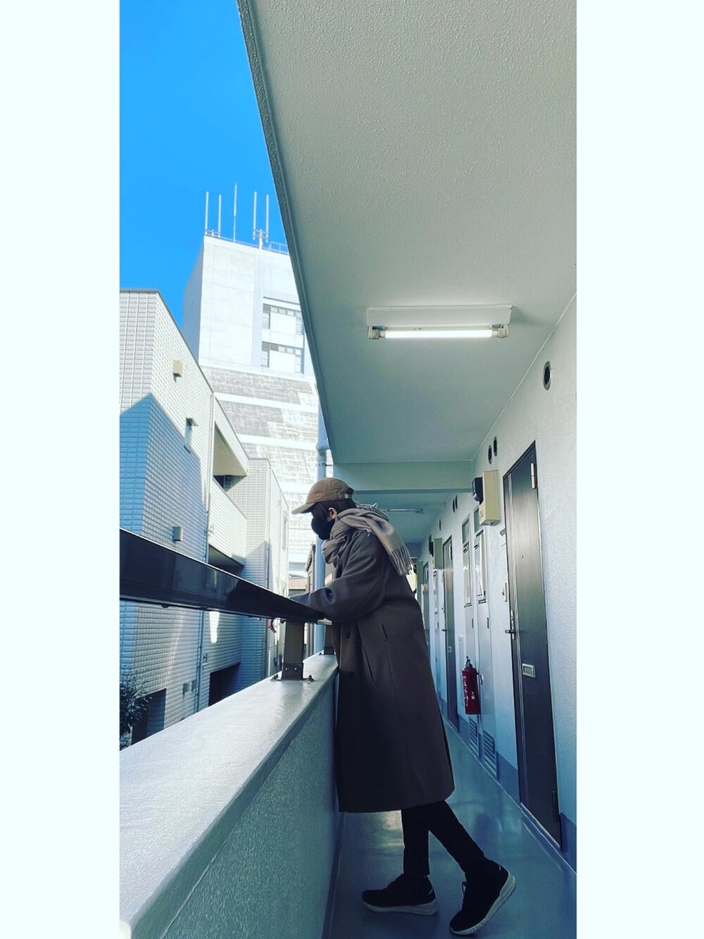 ブラウン系のチェスターコート、ブラック系のベスト、ホワイト系のTシャツ/カットソーを着用したメンズの冬コーディネートの2枚目の写真