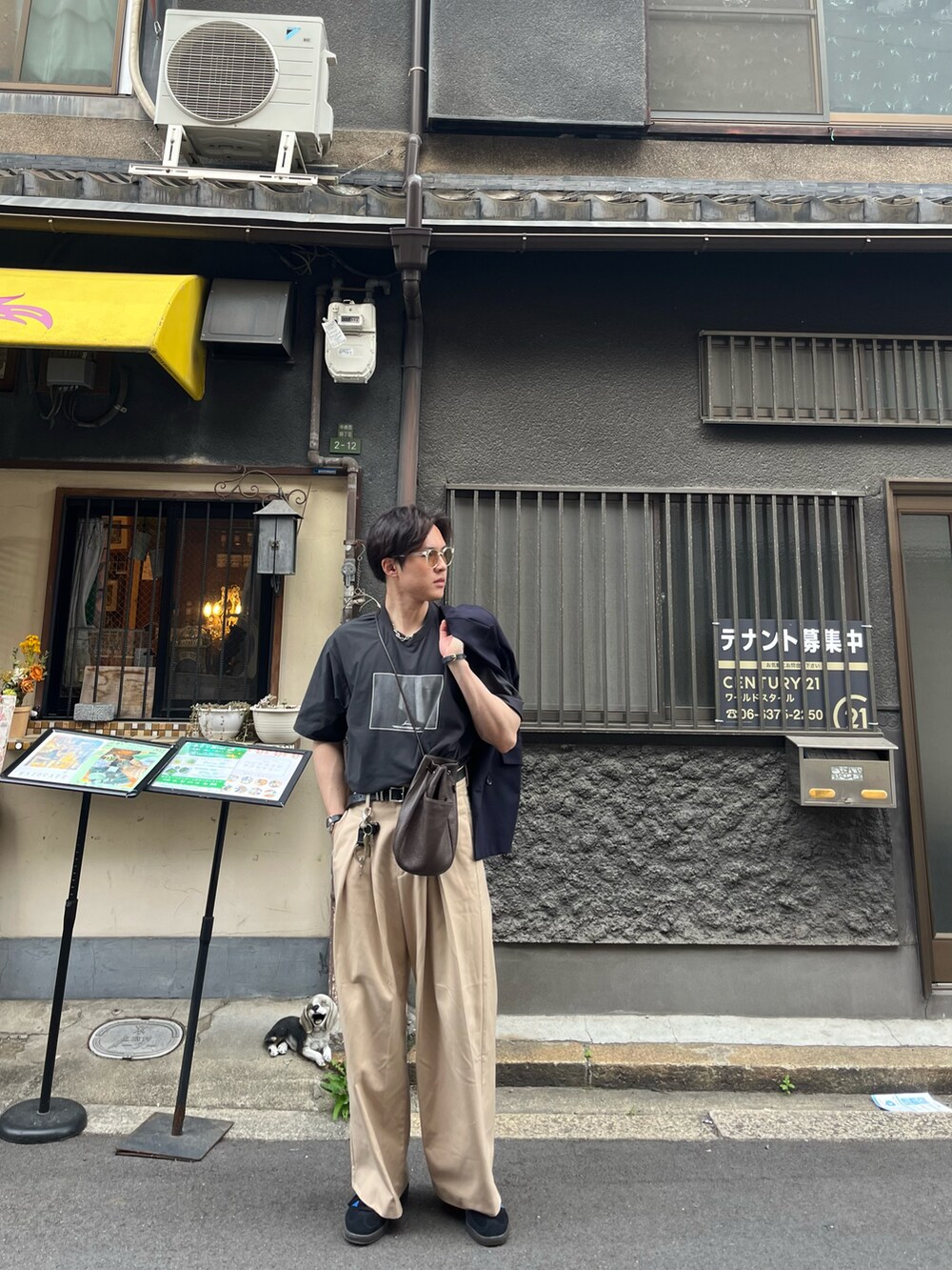 ベージュ系のその他パンツ、ブラック系のTシャツ/カットソー、ブルー系のスニーカーを着用したメンズの春コーディネートの2枚目の写真